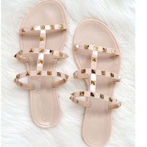 beige jelly sandals with studded detail.